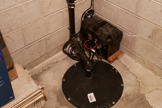 Pompe de puisard dans un sous-sol en béton.