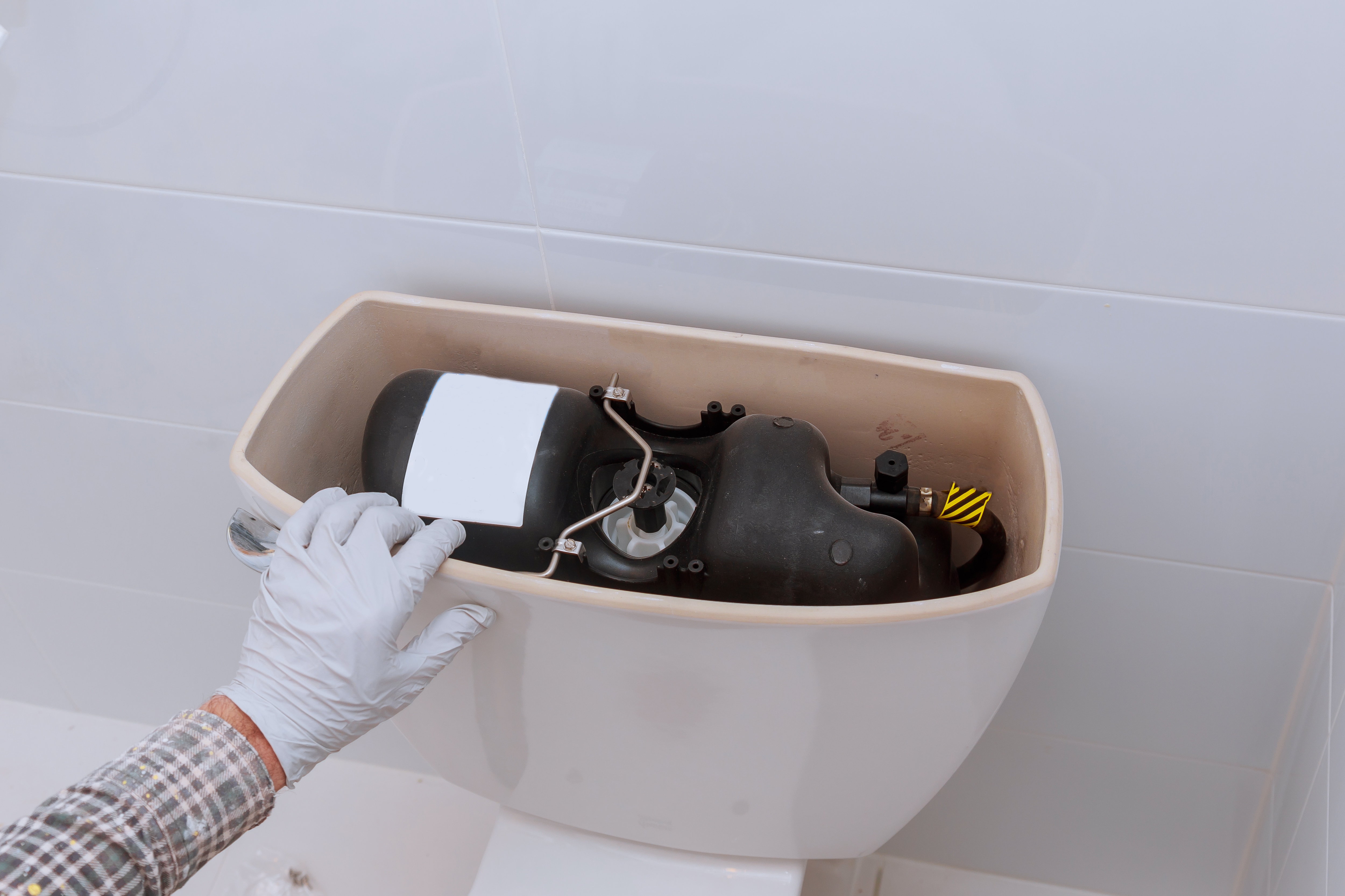 Réparation d'une chasse d'eau de toilettes ouverte.