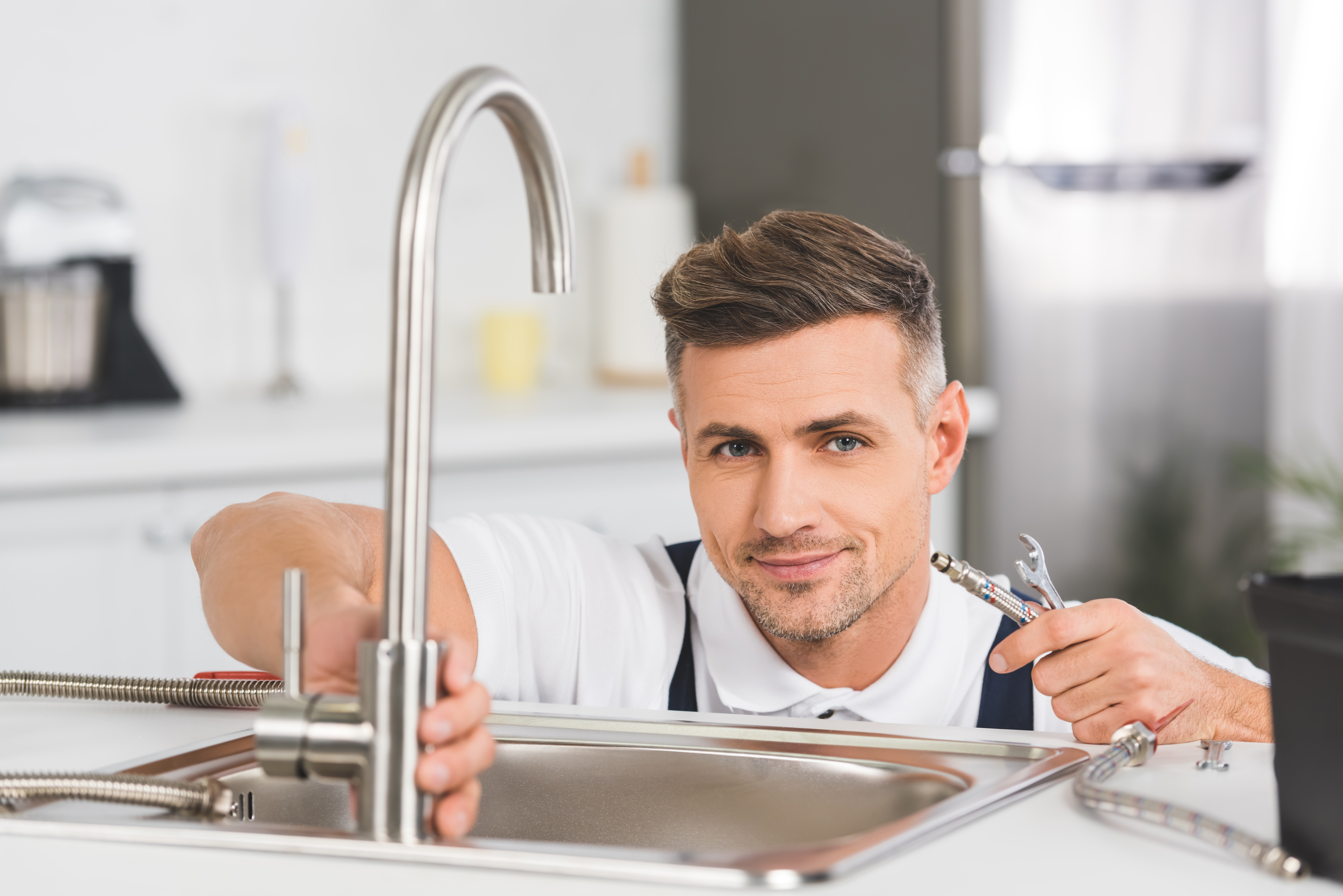 Plombier réparant un robinet de cuisine