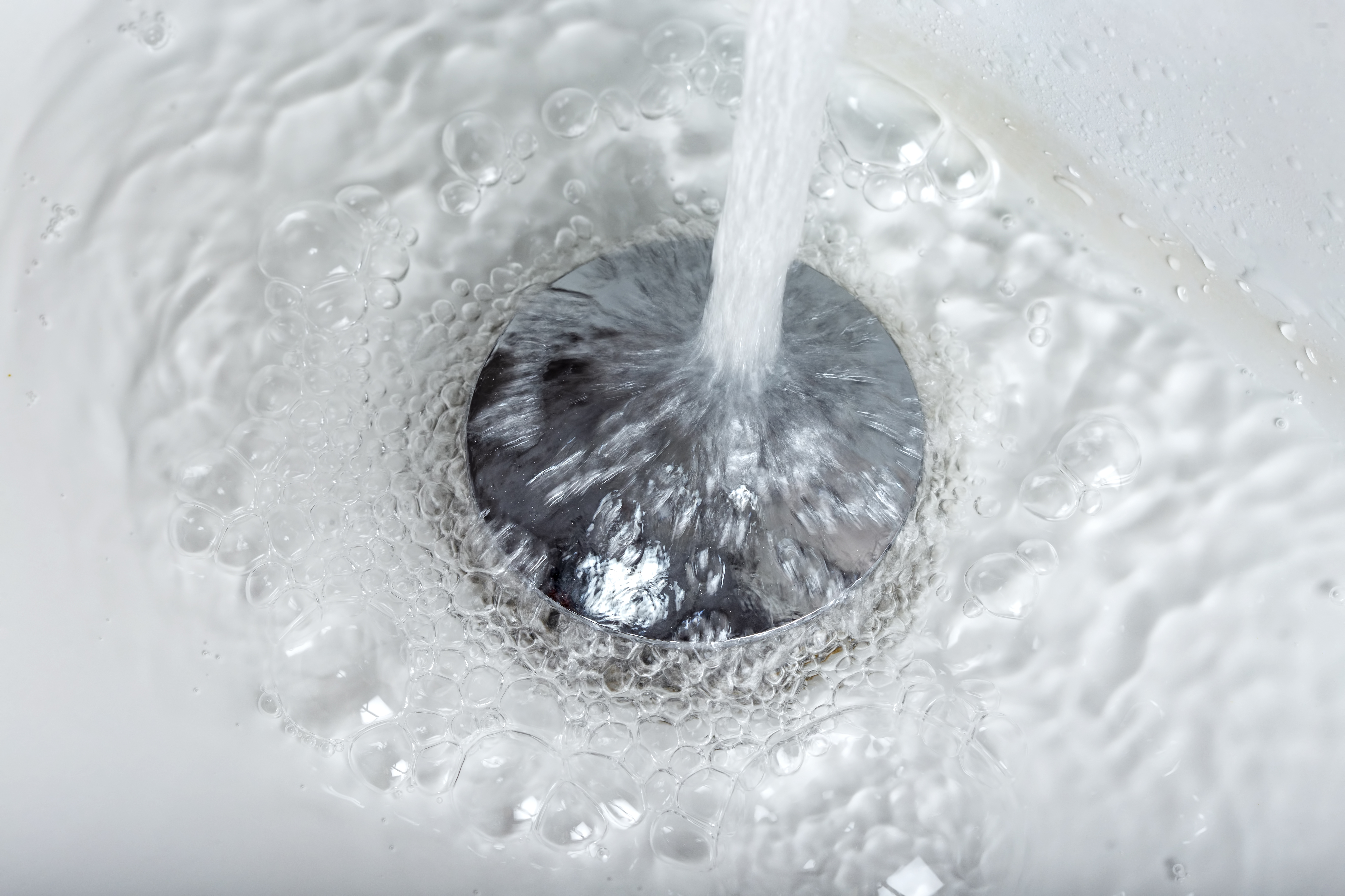 Eau coulant dans un évier en gros plan.